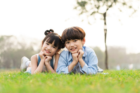image of brother and sister having fun in the parkの写真素材
