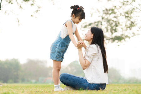 image of mother and daughter playing in the parkの写真素材