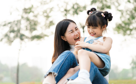 image of mother and daughter playing in the parkの写真素材