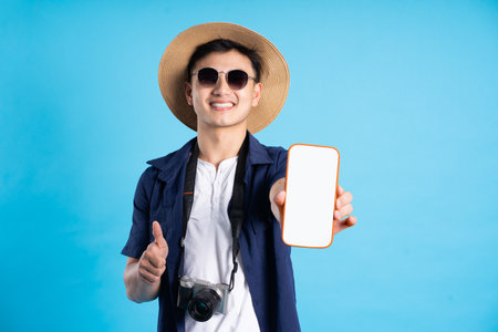 travel asian man portrait, isolated on blue backgroundの写真素材