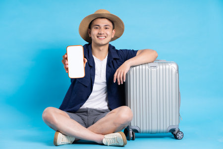 travel asian man portrait, isolated on blue backgroundの写真素材