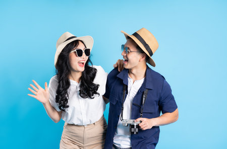 Asian couple traveling image  isolated on blue backgroundの写真素材