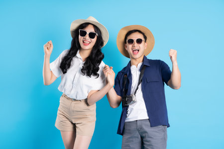 Asian couple traveling image  isolated on blue backgroundの写真素材