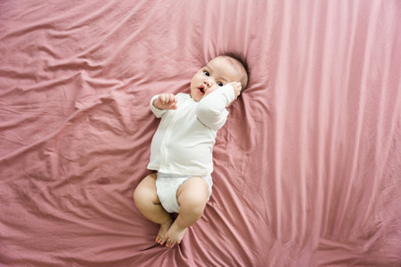 image of a newborn baby lying on a pink bed
