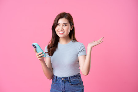 portrait of young asian girl posing on pink backgroundの写真素材