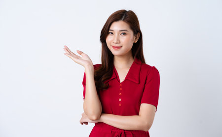 Portrait of a beautiful, charming lady wearing a red dress on a white backgroundの写真素材