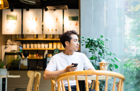 Asian man sitting at coffee shopの写真素材