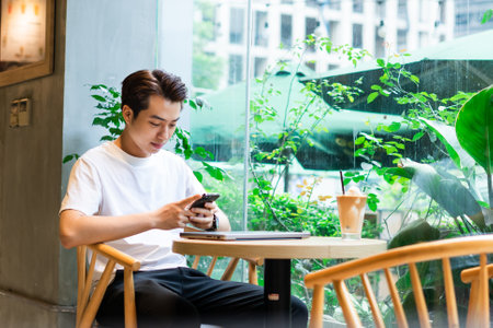 Asian man sitting at coffee shopの写真素材