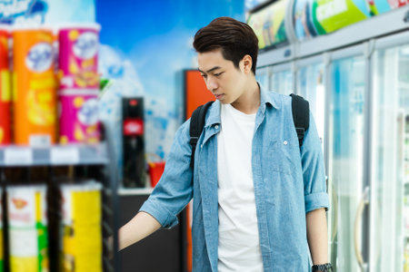 image of Asian man shopping at a convenience storeの写真素材