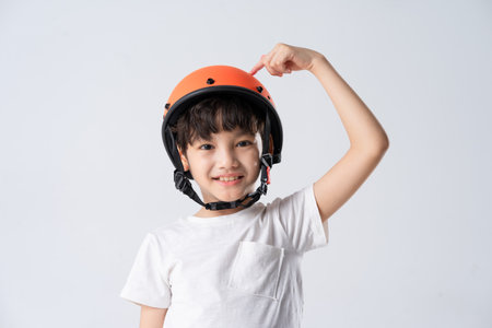portrait of asian boy wearing orange helmet on white backgroundの写真素材