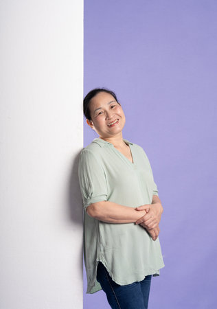 Gangang middle-aged Asian female portrait posing on purple backgroundの写真素材