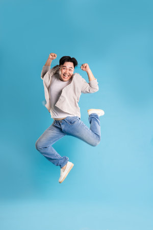 Full body image of Asian man posing on blue background