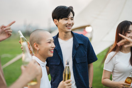 Image of group of friends celebrating and drinking beer togetherの写真素材