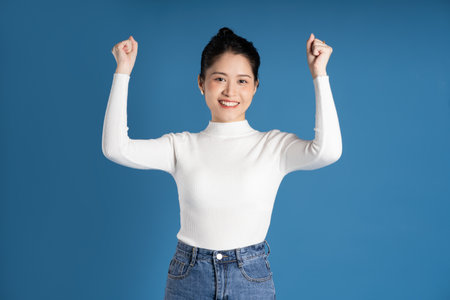 Portrait of beautiful asian woman posing on blue background
