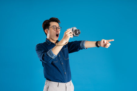 Portrait of young Asian business man posing on blue background
