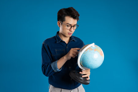 Portrait of young Asian business man posing on blue backgroundの写真素材
