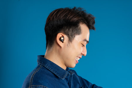 Portrait of young Asian business man posing on blue background