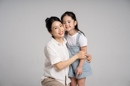 Portrait of an Asian mother and daughter posing on a white backgroundの写真素材