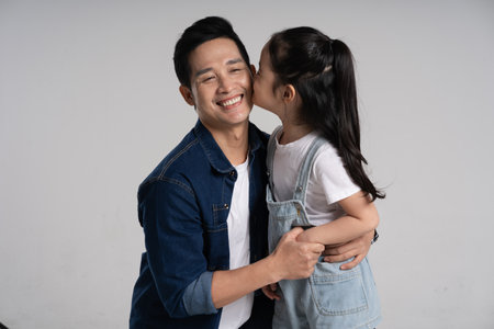 Portrait of father and daughter posing on white backgroundの写真素材
