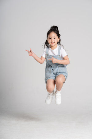 Portrait of a lovely Asian baby girl posing on a white backgroundの写真素材