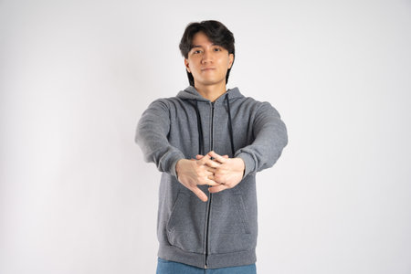 Portrait of asian man wearing hoodie posing on white backgroundの写真素材