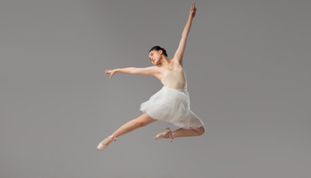Ballet Dancer in Mid-Air: Graceful leap Light-toned leotard and white skirt Studio setting Elegant...