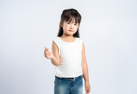 Portrait of beautiful Asian girl posing on white background, child