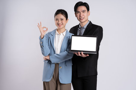 Image of an Asian business couple posing on a white background