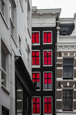 Red windows in Amsterdam on a narrow facadeの写真素材