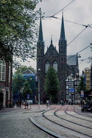 Amsterdam/Niederlande/ July 18, 2019: Leading tram tracks to a gothic cathedral in Amsterdamの写真素材