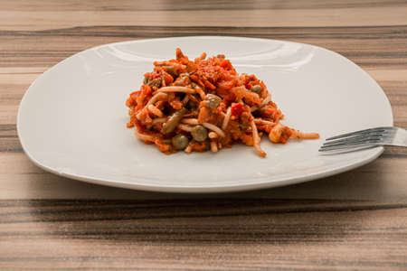 Perfect portion of pasta with red sauce on a white plate