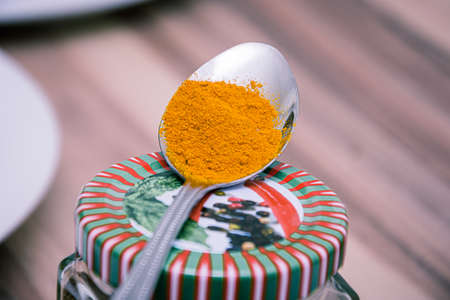 Exact portion of Indian orange spice on a metal spoonの写真素材