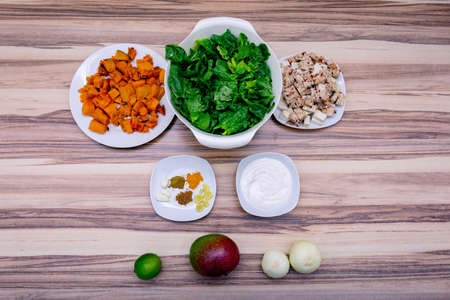 Green lettuce and other ingredients prepared for vegetarian meal on the wooden tableの写真素材
