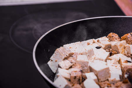 Macro shot of fried tofu mix in oil making smoke