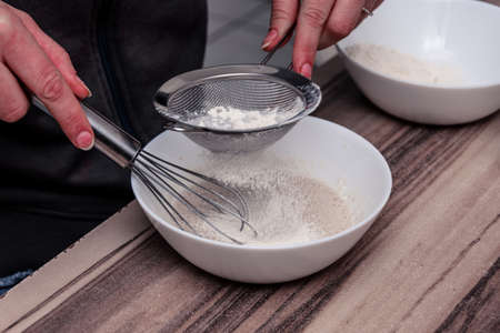 Close up of sprinkling dough with white flour bread in the kitchenの写真素材