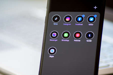 Vienna / Austria / November 13, 2020: Black shiny thin smartphone with different social media apps