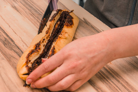 Cutting the dough of chocolate cake with a sharp black knifeの写真素材