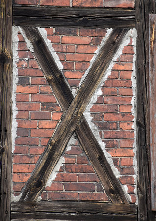 Detail of an old wooden door with a white brick wall.の写真素材