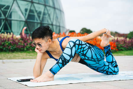 Young women practice yoga in the parkの写真素材