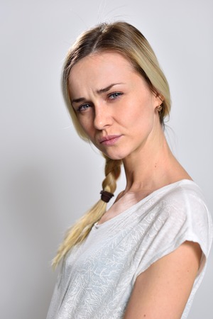 blonde girl expresses suspicion with his eyes.の写真素材