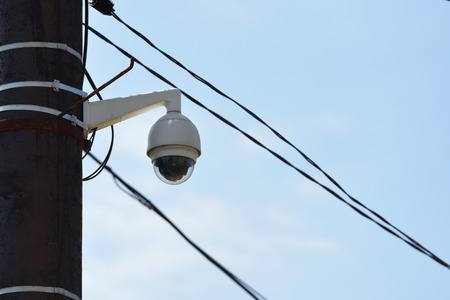 CCTV camera on a pillar in the city against the sky.