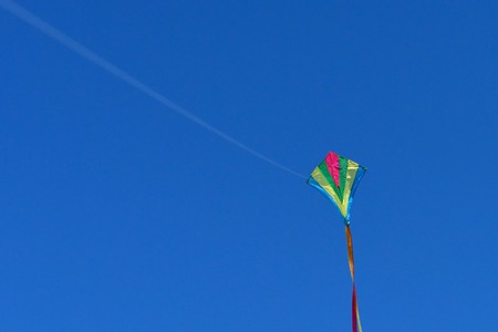 A kite flies in a clear and blue sky on a sunny day.の写真素材