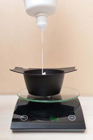 The paint for dyeing the hair is squeezed into the container.の写真素材