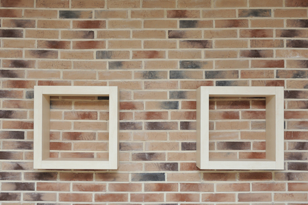 Shelves in the form of squares mounted on a brick wall.の写真素材