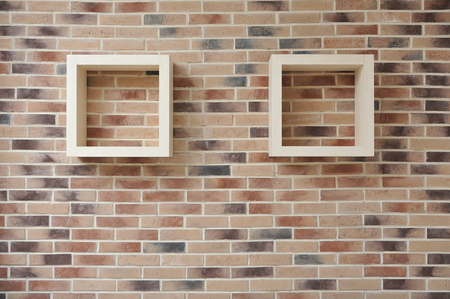 Shelves in the form of squares mounted on a brick wall.の写真素材