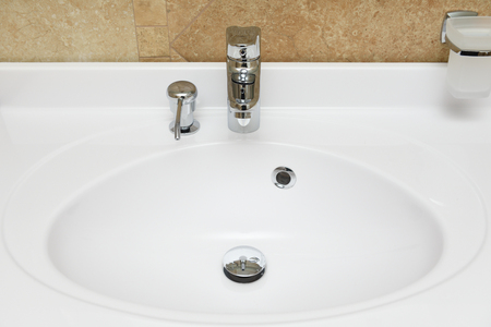Beautiful white washbasin with built-in soap dish for liquid soap.の写真素材
