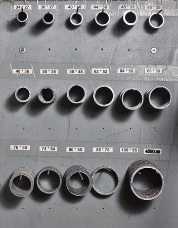 Gaskets of different sizes for the assembly of water valve, sorted and hanging on the stand.