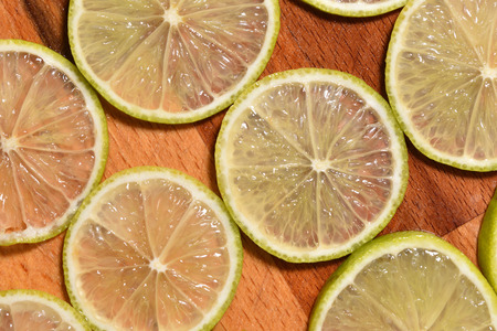 Fresh and bright sliced lime on a wooden surface.