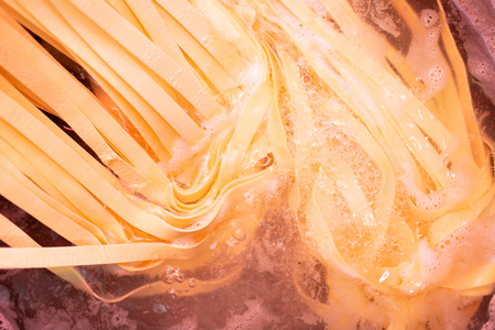 Spaghetti for cooking pasta is boiled in a pan in boiling water.の写真素材