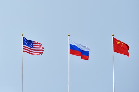 Beautiful and bright flags of the Russia, China and the United States of America against the sky....